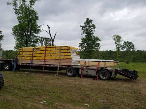 Modern house kit delivered on a semi truck in a rural area