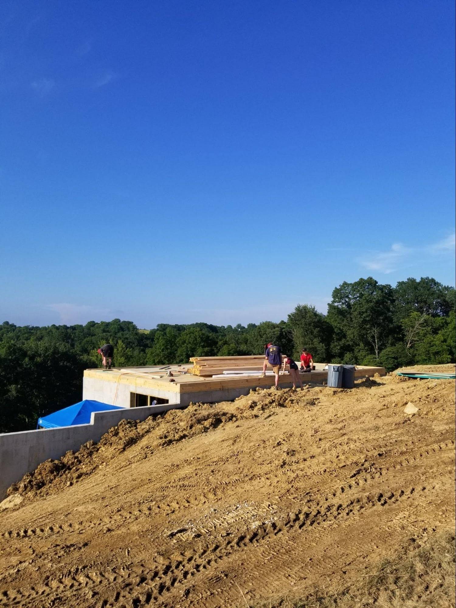 MSH 20190610 outdoors Summer construction foundation workers pallet Wide Shot PX min