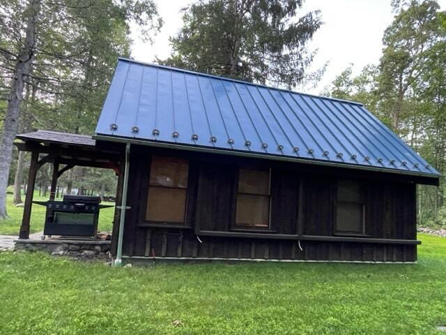 MSH 20230707 rural suburb New York City outdoor finished wood paneling blue roof snow spikes grill side view porch PX min