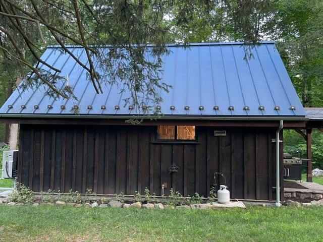 MSH 20230707 rural suburb New York City outdoors finished brown paneling blue roof snow spikes side view porch PX min