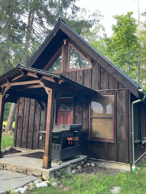 MSH 20230707 rural suburb New York City outdoors finished brown paneling porch front view grill PX min