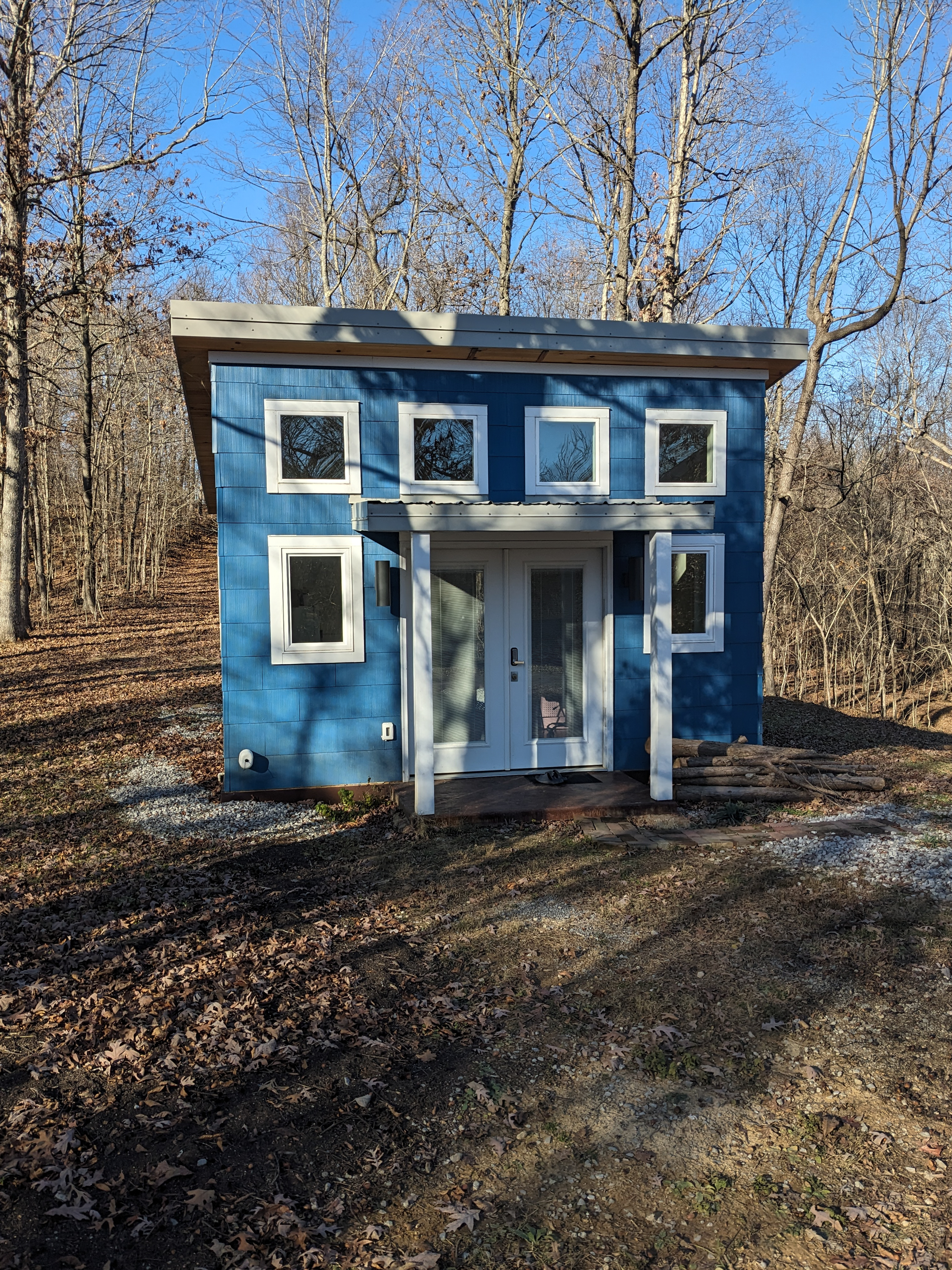 MSH 20231215 customer build modern outdoors finished blue siding white trim winter front side view PX