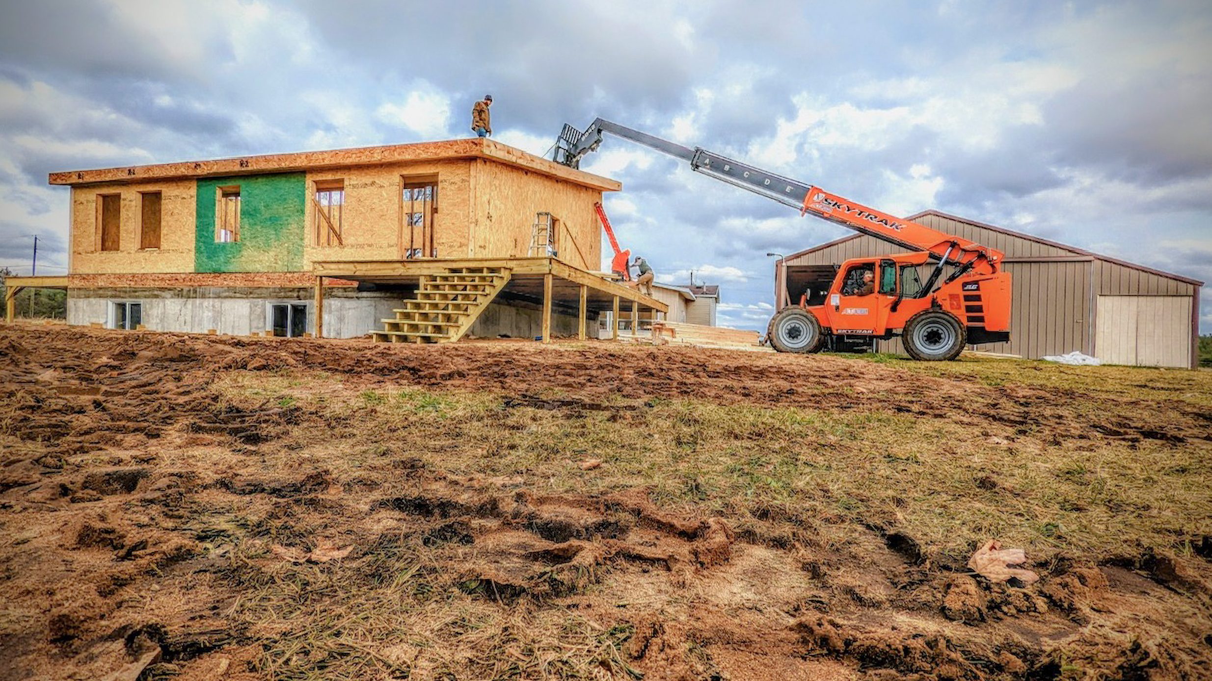 Telehandler placing the last roof panel on the Michigan Modern Customer Build