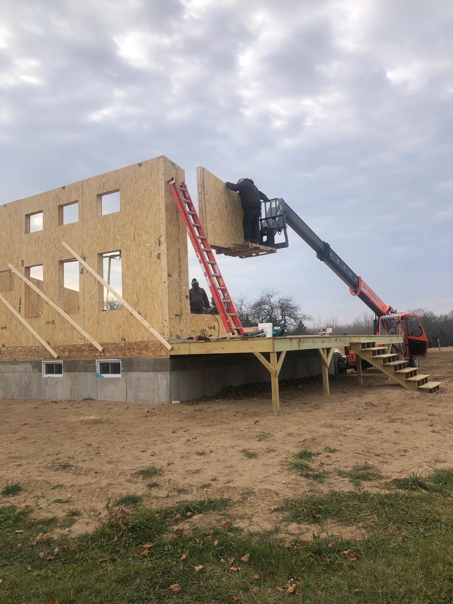 Telehandler lifting up a SIPs panel on the Michigan Modern Customer Build