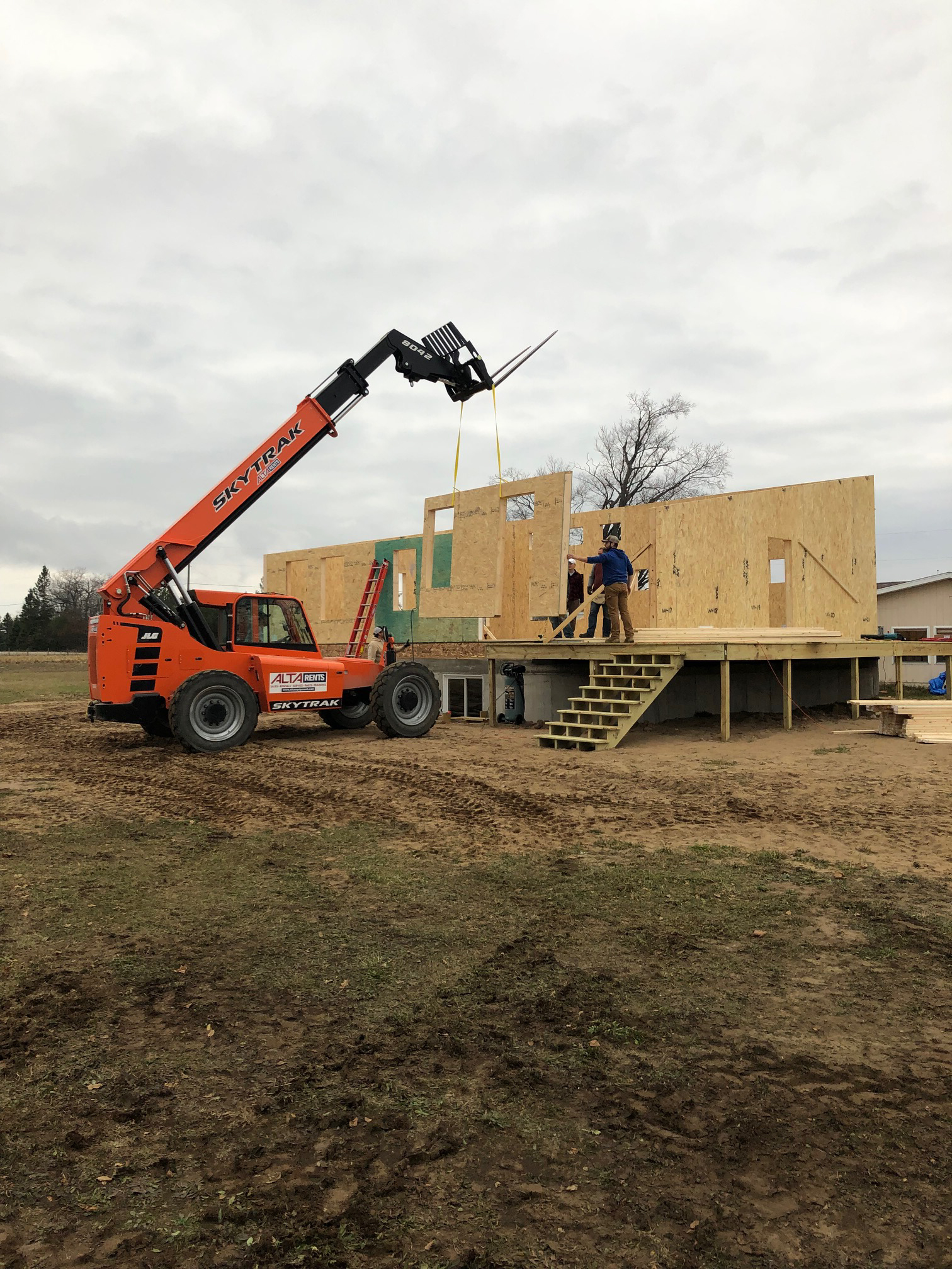 Telehandler placing SIPs panel on the side of Michigan Modern Customer Build