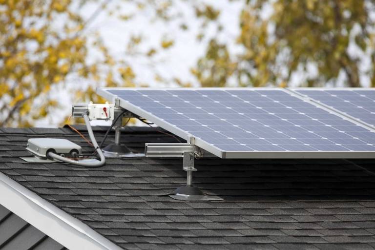 residential solar panels mounted on a roof, illustrating a solar power system that generates electricity and supports battery storage for off-grid home living