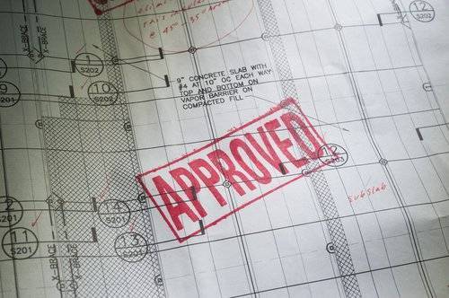 photo of home construction plans with permit approval stamp