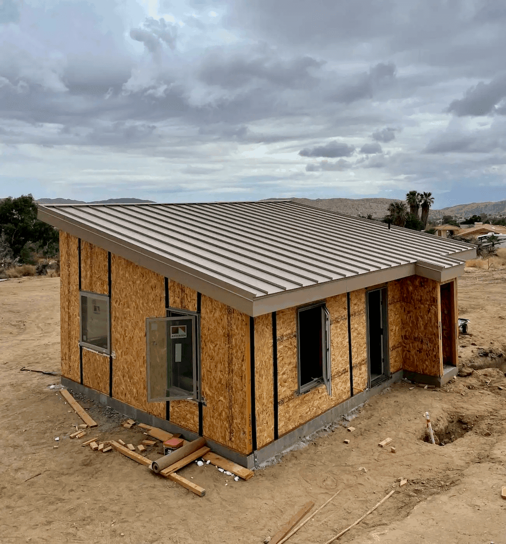 Modern model kit home built in California desert under roof with some windows installed