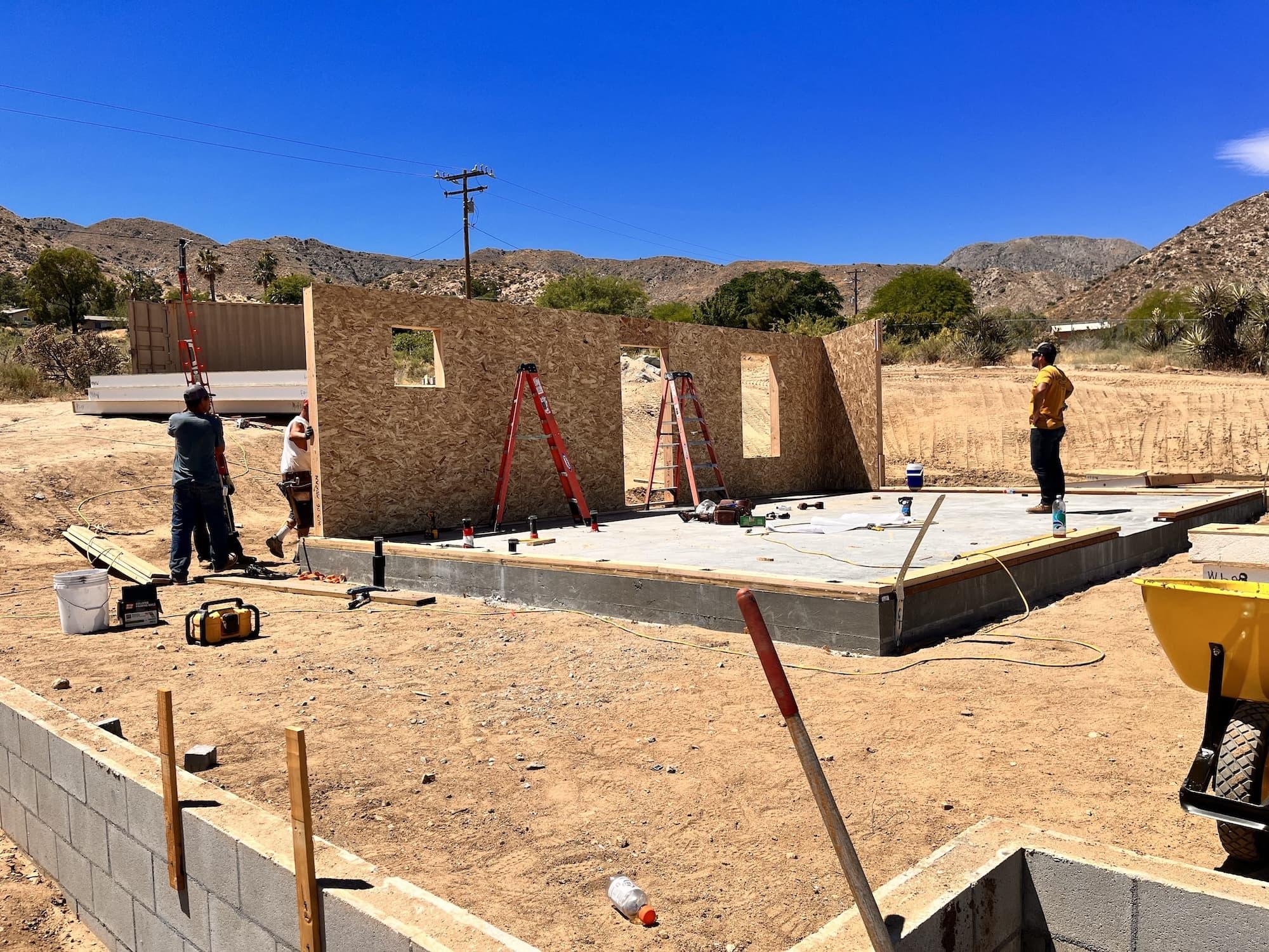 SIP wall panels being assembled on a foundation in Morongo Valley, California, creating a high-performance building envelope that reduces heating and cooling demands in extreme desert temperatures