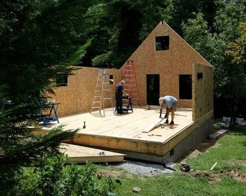 photo of cottage house kit model being built in wooded area