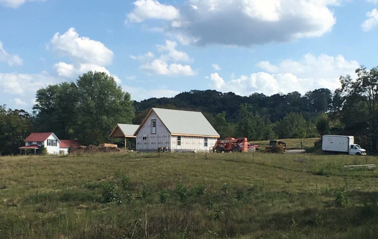 A rear-view photo of an MSH Cottage from across a field