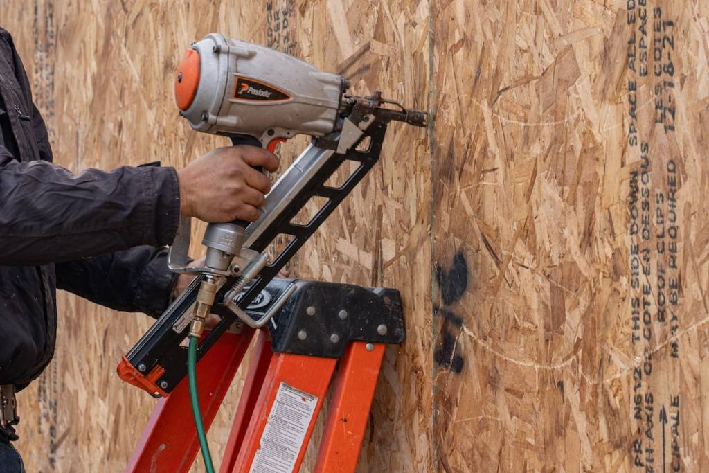 Worker placing nails into panels