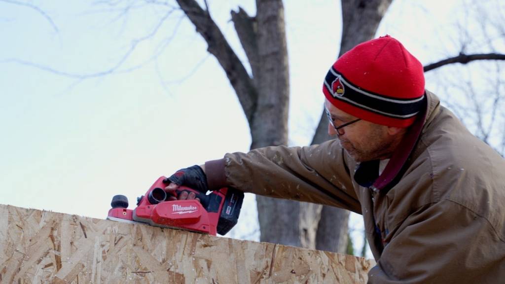 Worker leveling the top of a panel