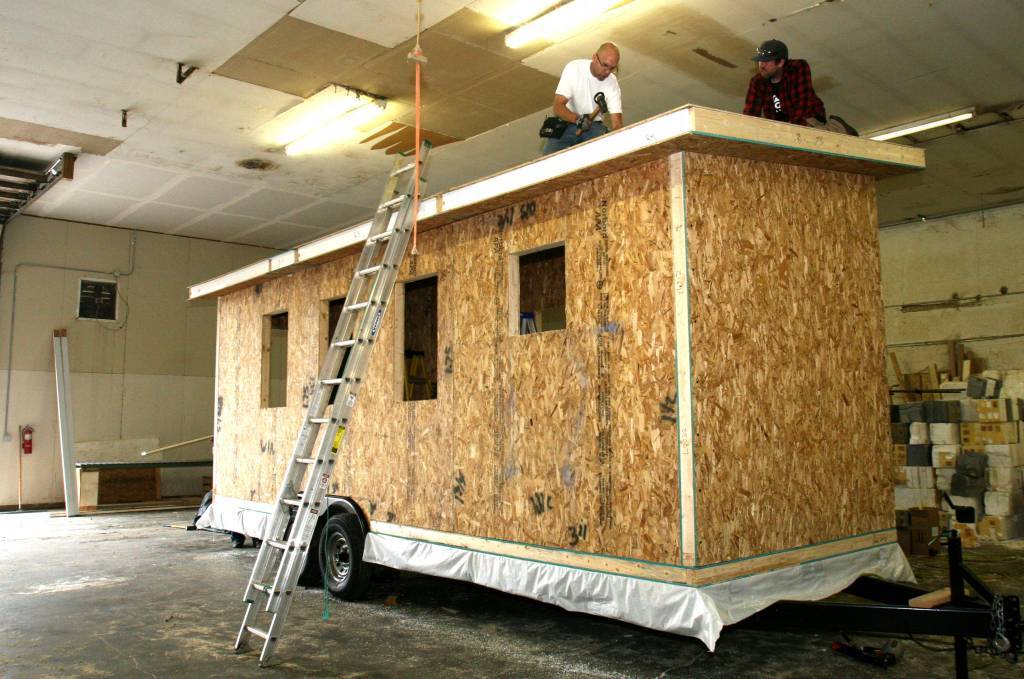 Photo of workers installing the roof on a Tiny