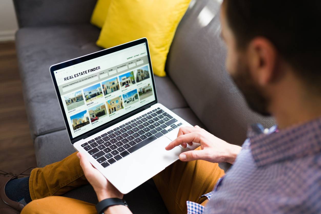 Image of man viewing homes with a laptop