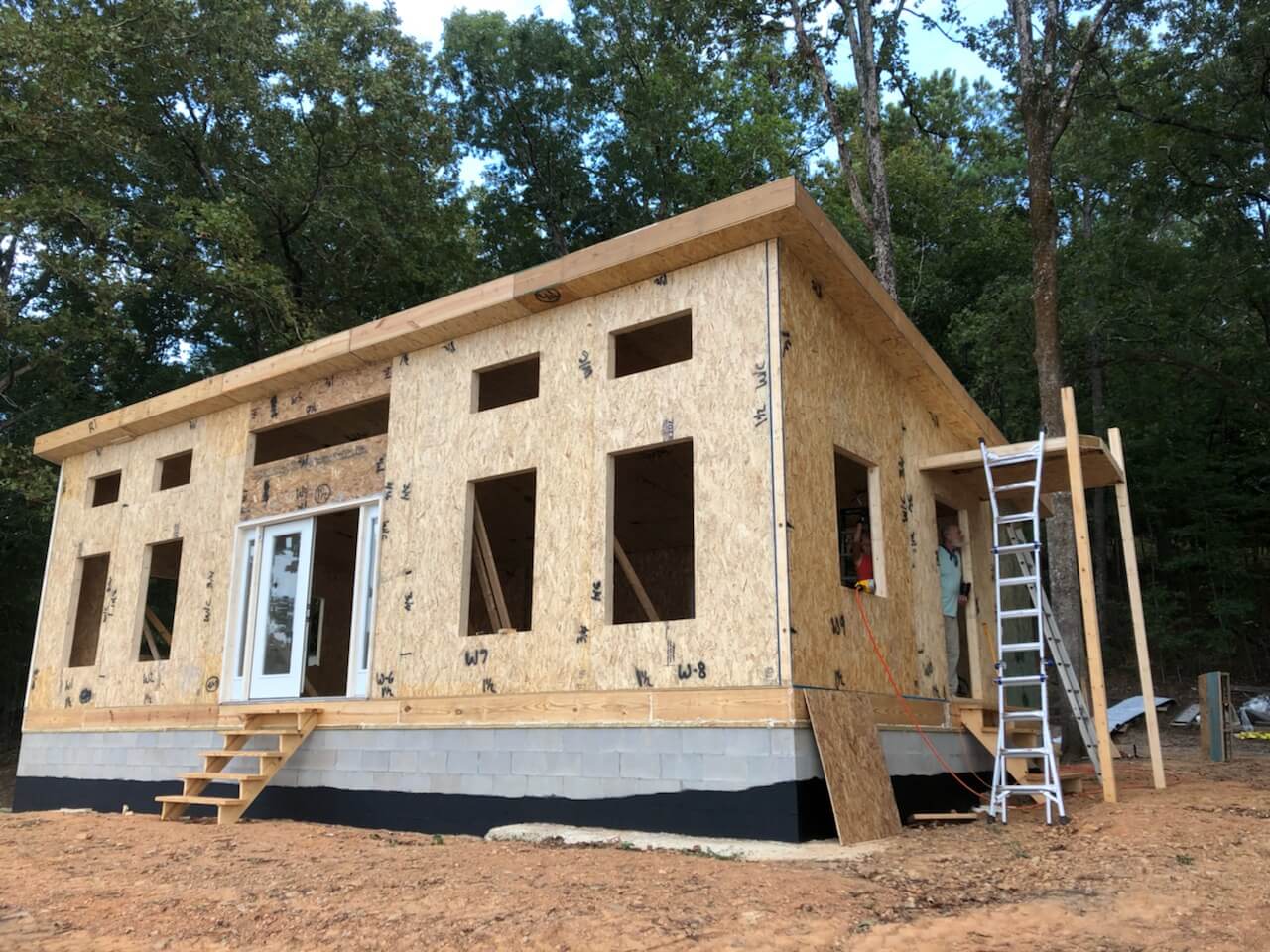 Photo of a man inspecting the side porch roof on an 800 square foot Modern