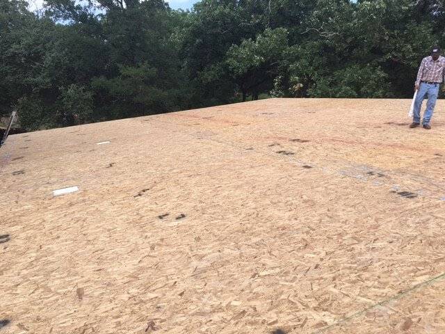 Photo of a worker walking the roof panels of a custom Modern