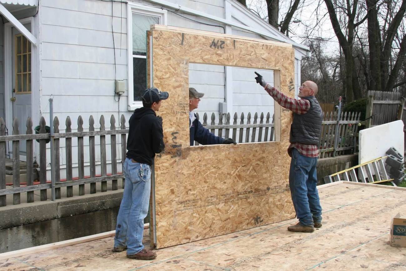 Photo of workers moving a wall panel into place