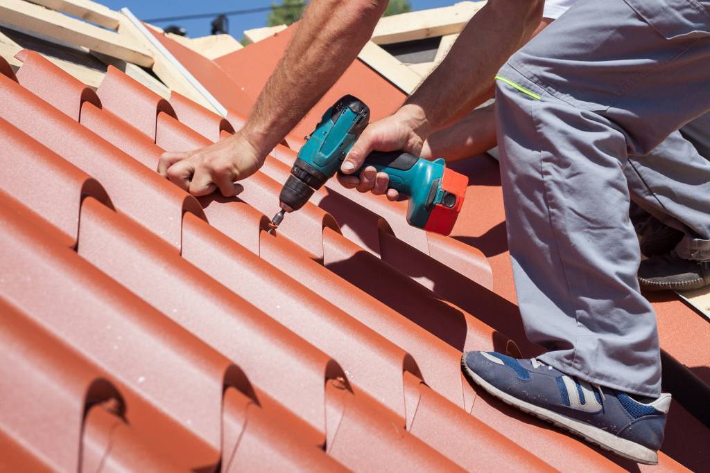 Photo of a workman installing roofing tiles