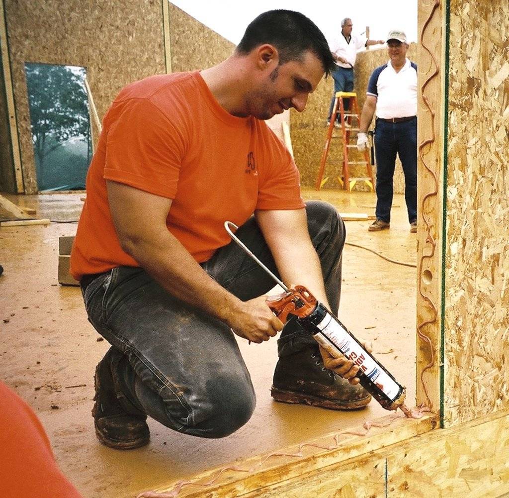 A workman placing adhesive caulk