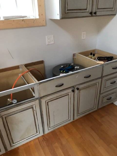 Photo of unfinished kitchen sink and cabinets in a Cottage