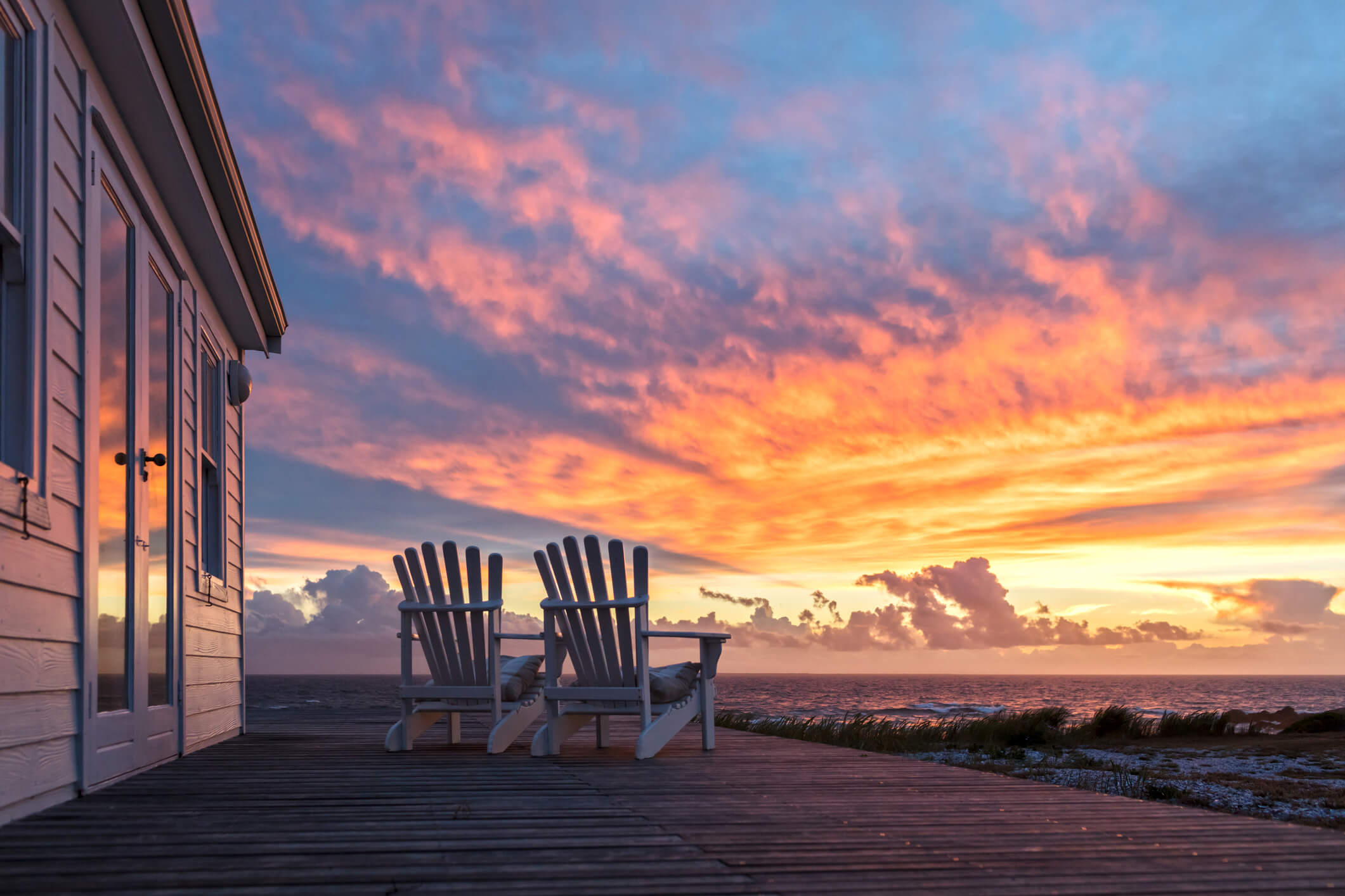 adirondack chairs outside a vacation home at sunset