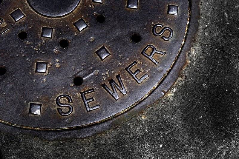closeup photo of sewer manhole cover
